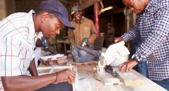 Three men at work in a carpentry workshop South Africa