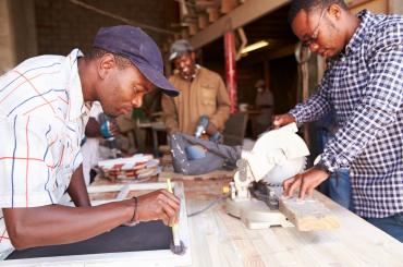 Three men at work in a carpentry workshop South Africa