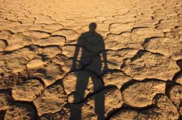 Man standing in desert with shadow behind him